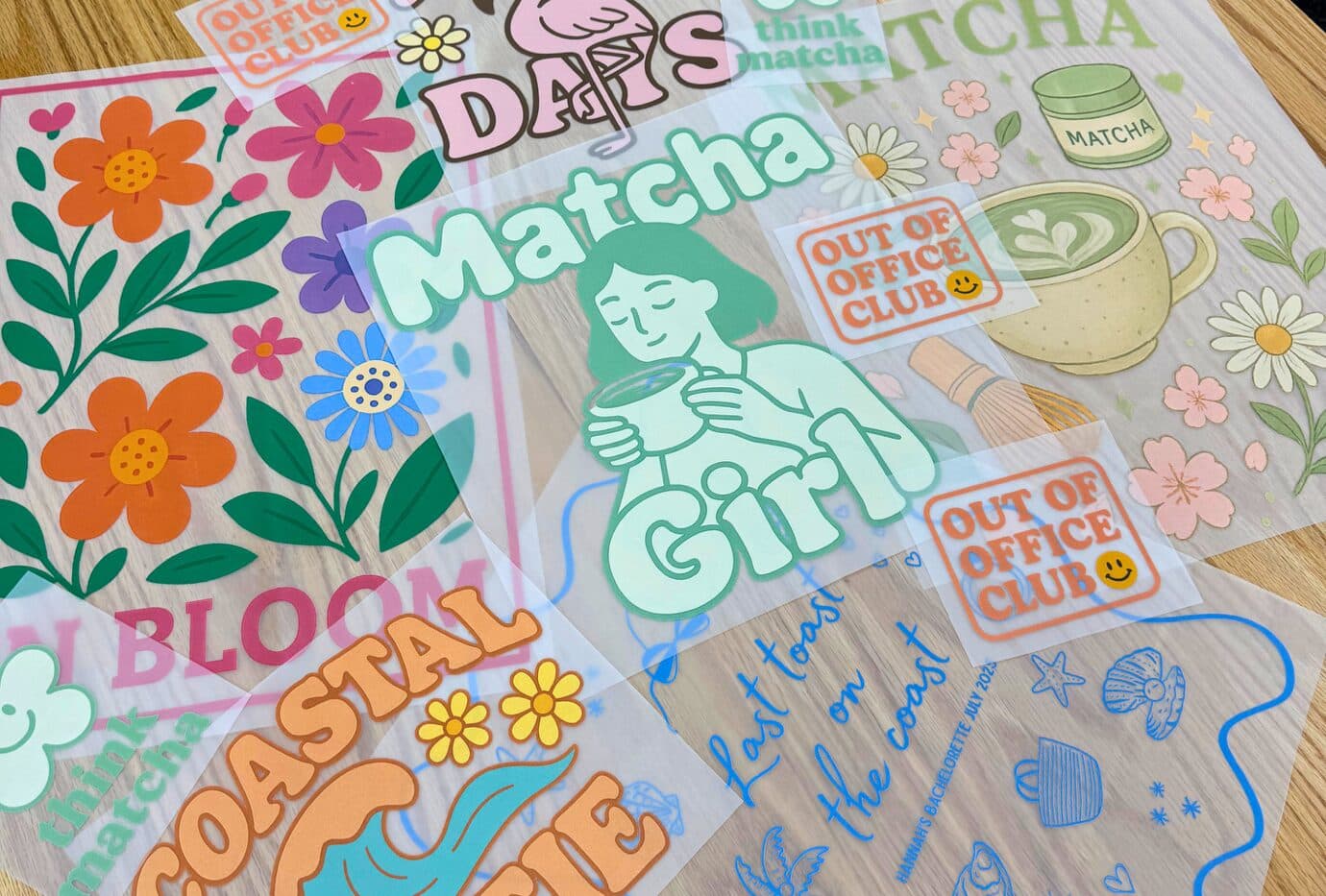 A spread of colourful Supacolour heat transfer sheets on a wooden table