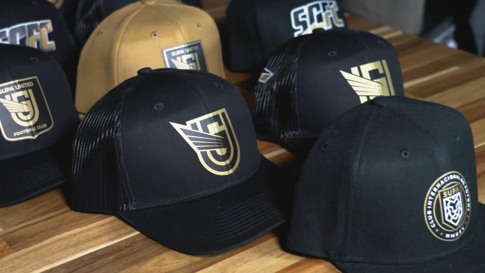 Black and gold structured caps decorated with gold Supacolour Headwear crests